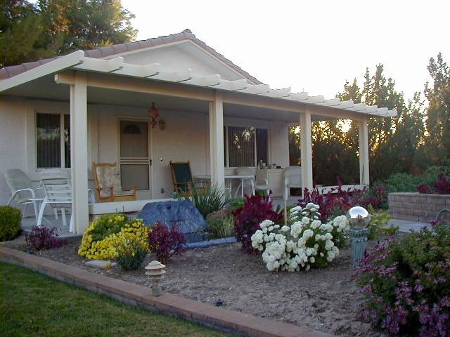 Solid Patio Cover on home with flower garden in yard