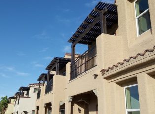 Brown open lattice balcony cover on townhomes