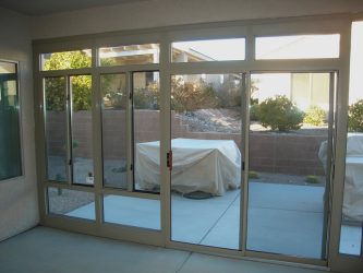 View looking out into yard from glass enclosure